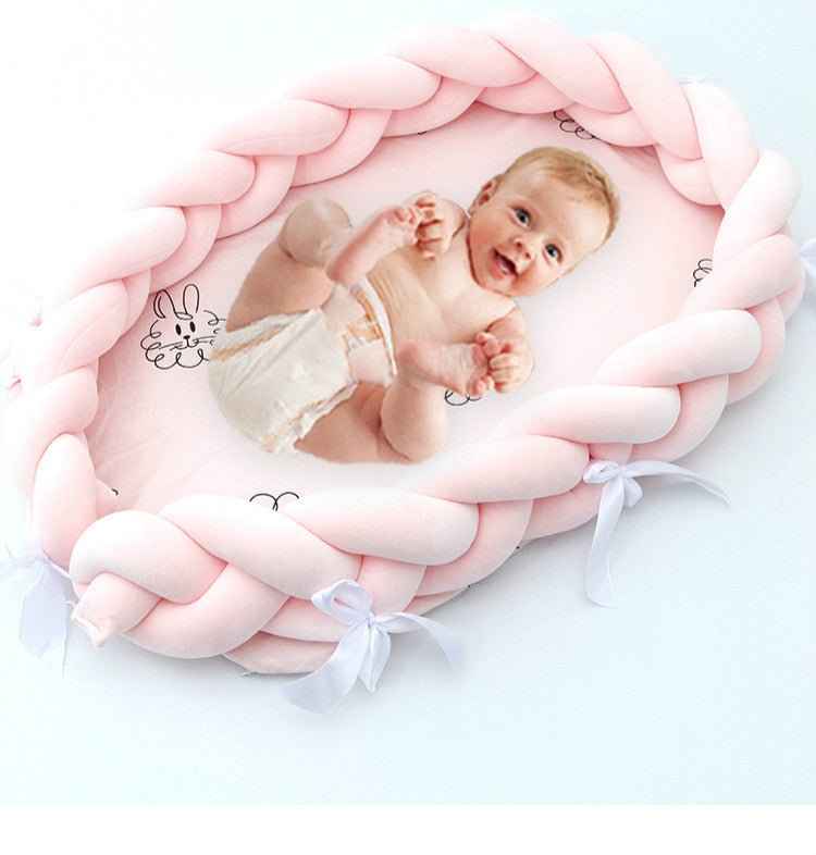Pink braided baby lounger nest bed top view showing padded cushion and cozy design