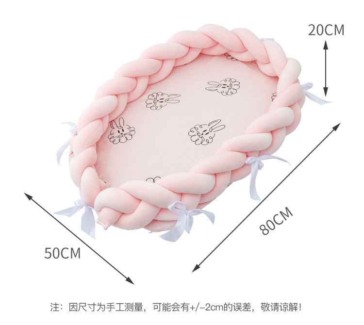 Coral braided baby lounge nest bed side profile displaying oval shape and soft material